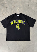 Black | Black t-shirt with 'Wyoming' and a logo on a concrete floor