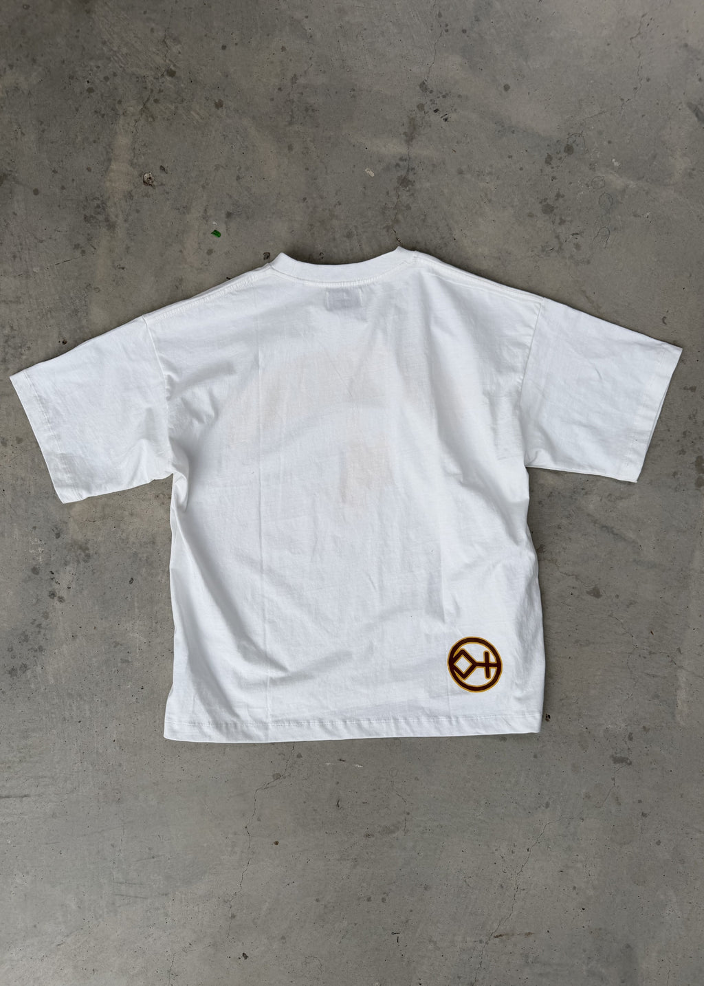 White | White t-shirt with a logo on a gray concrete surface