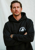 Sun Faded Black | Man wearing a black hoodie with a logo on a light gray background