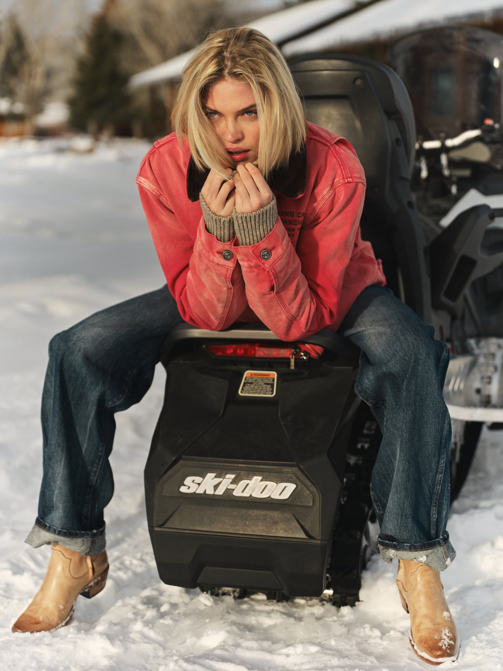 Faded Red | Person sitting on a Ski-Doo snowmobile in a snowy setting