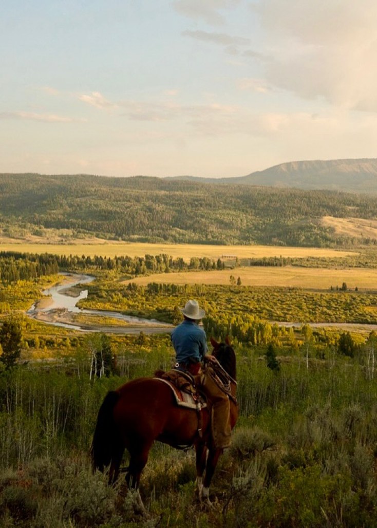 A rider on horseback looking out over the river valley