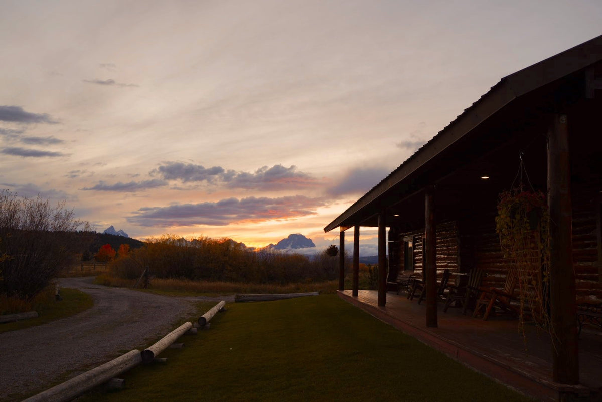 Teton Cabins porch at sunset with the Grand Tetons in the distance