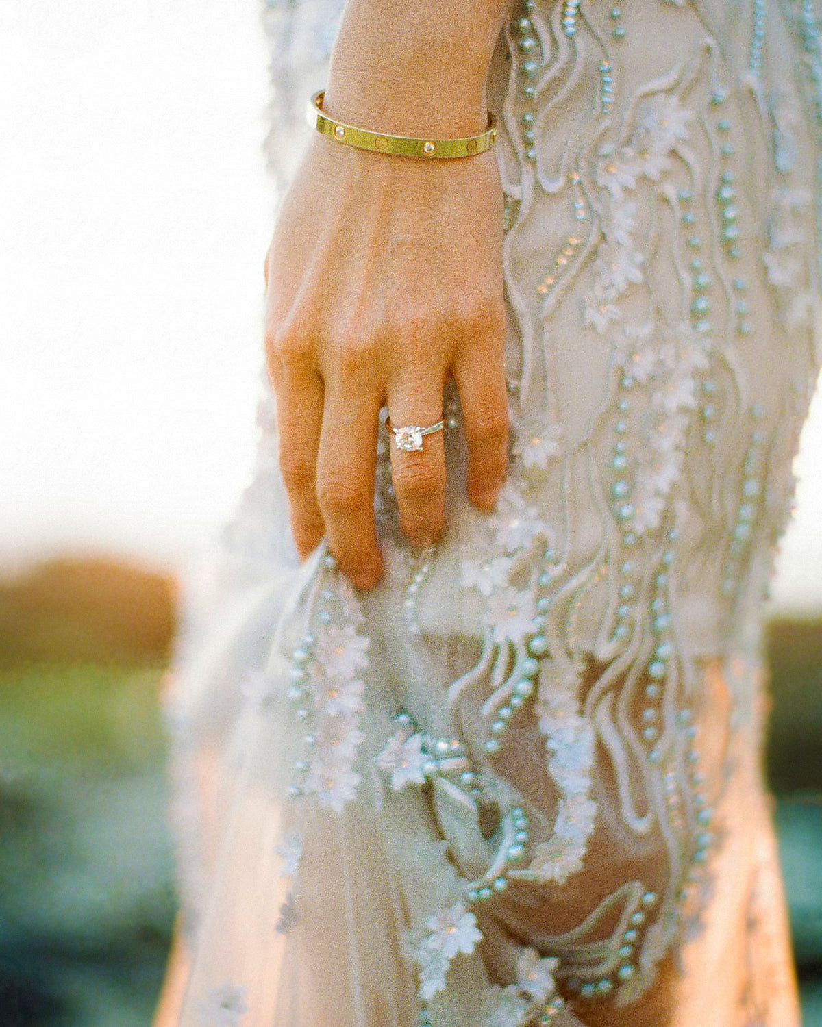 Bride's hand and beaded dress