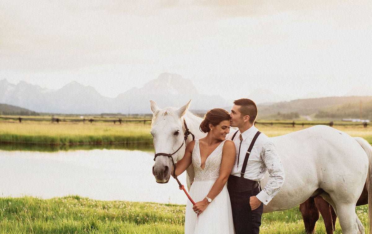 Couple with a white horse at the pond